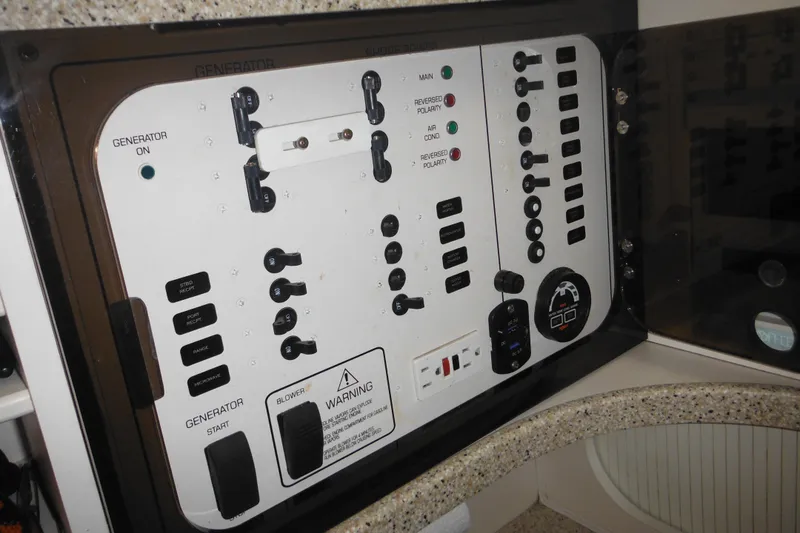 Slide: The Image of Control panel of a 2000 Rinker 330 Fiesta Vee boat, featuring various switches and indicators. - 47