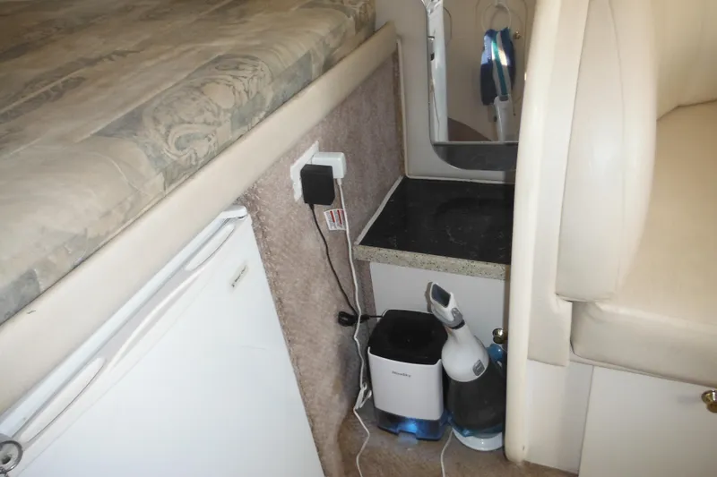 Slide: The Image of Interior of 2000 Rinker 330 Fiesta Vee with bed, mini fridge, and appliances. - 48