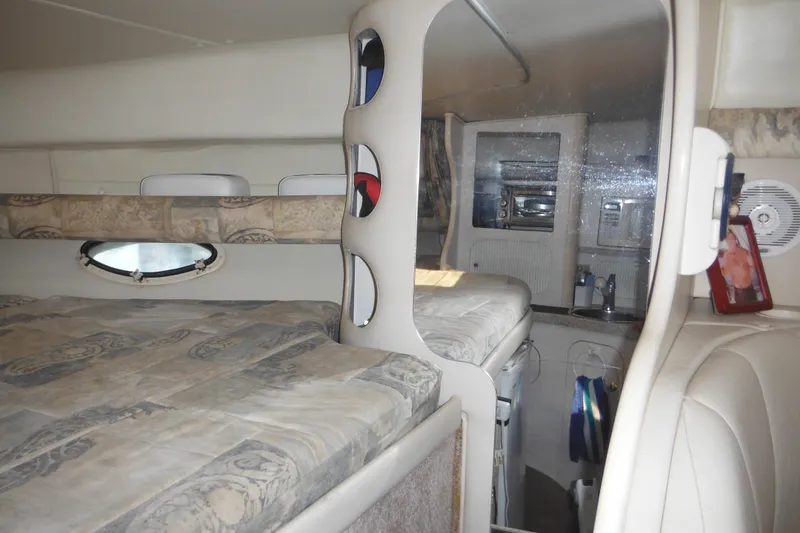 Slide: The Image of Interior of 2000 Rinker 330 Fiesta Vee boat, featuring cozy cabin and kitchenette. - 49