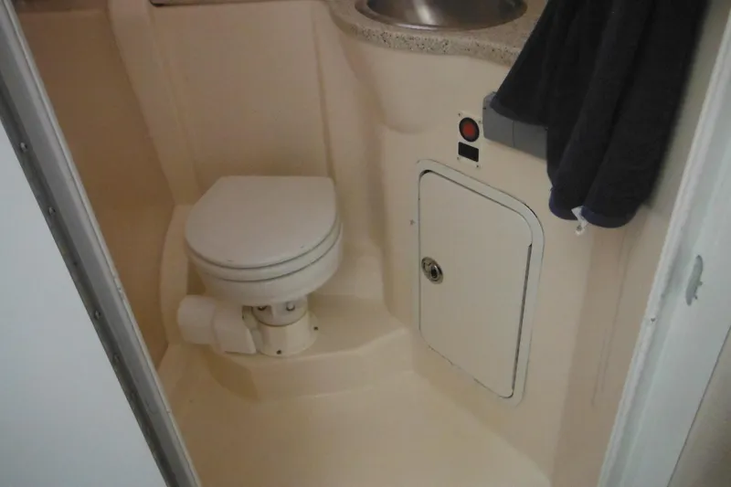 Slide: The Image of Compact bathroom in 2000 Rinker 330 Fiesta Vee boat, featuring toilet and sink. - 54