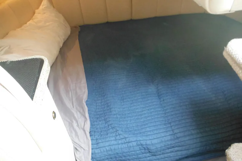 Slide: The Image of Interior cabin bed of 2000 Rinker 330 Fiesta Vee boat with blue bedding. - 56