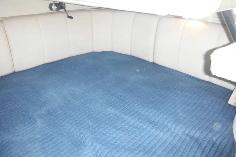 Slide: The Image of Interior cabin of 2000 Rinker 330 Fiesta Vee with blue quilted bedding. - 57