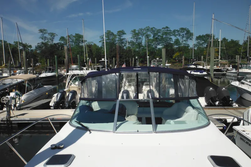 Slide: The Image of 2000 Rinker 330 Fiesta Vee boat docked in a marina with clear blue skies. - 72