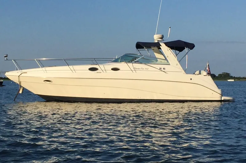 Slide: The Image of 2000 Rinker 330 Fiesta Vee boat on calm water under clear sky. - 78