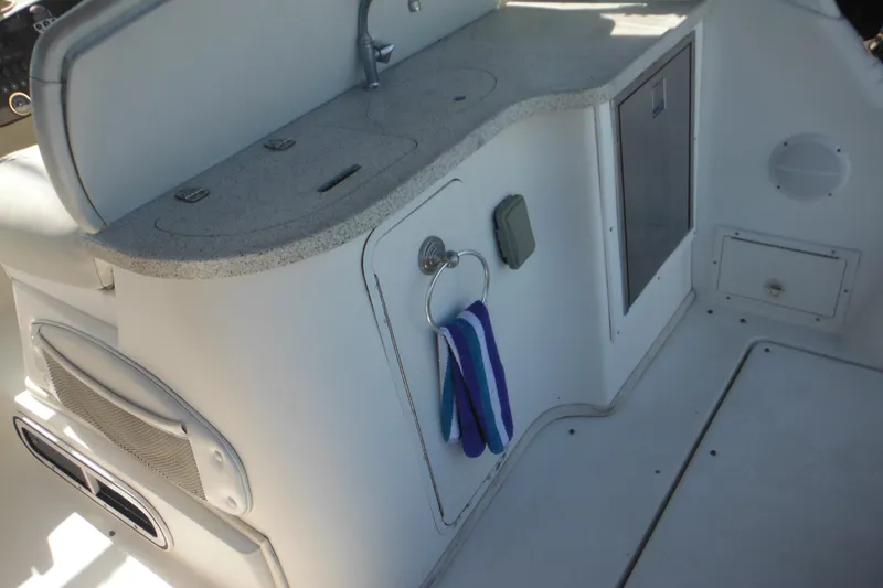 Slide: The Image of Interior of 2000 Rinker 330 Fiesta Vee boat with kitchenette and storage. - 8