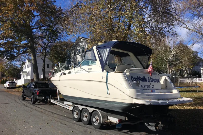 Slide: The Image of 2000 Rinker 330 Fiesta Vee boat on trailer, parked on a residential street. - 80