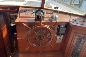 Slide: The Image of 1982 Mainship Trawler helm with wooden wheel and navigational controls. - 11