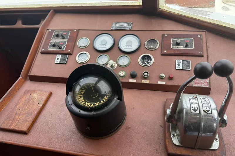 Slide: The Image of Control panel of a 1982 Albin 49 Trawler with compass and throttle levers. - 12