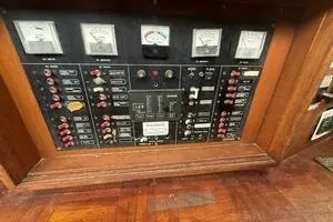 Slide: The Image of 1982 Mainship Trawler control panel with gauges and switches in a wooden frame. - 14