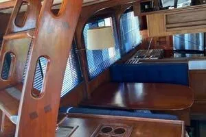 Slide: The Image of 1982 Mainship Trawler interior with wooden furnishings and blue seating. - 20