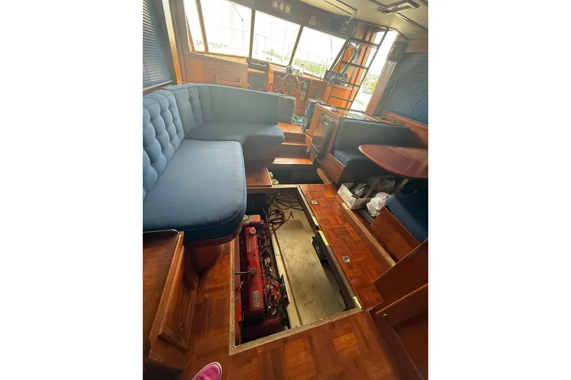 Slide: The Image of Interior of 1982 Albin 49 Trawler with open engine compartment, blue seating, and wooden flooring. - 22