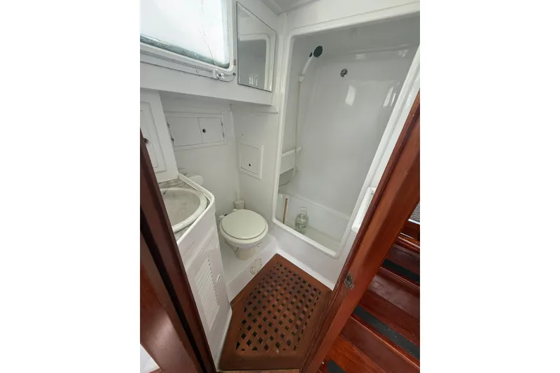 Slide: The Image of 1982 Albin 49 Trawler bathroom with shower, toilet, and wooden flooring. - 29