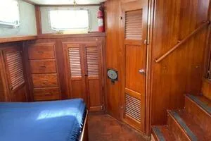 Slide: The Image of 1982 Mainship Trawler interior with wooden cabinetry and blue bedding. - 30