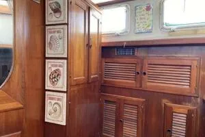 Slide: The Image of 1982 Mainship Trawler interior with wooden cabinets and nautical decor. - 32