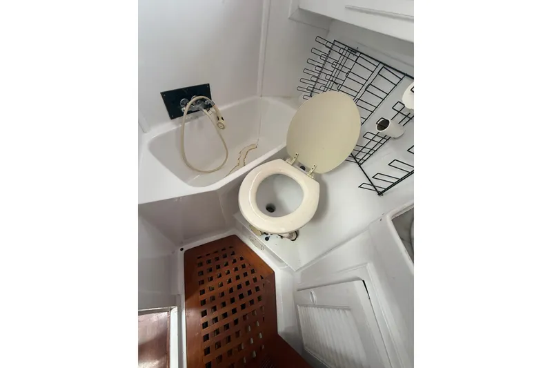 Slide: The Image of 1982 Albin 49 Trawler bathroom with toilet, shower, and wooden floor grate. - 36