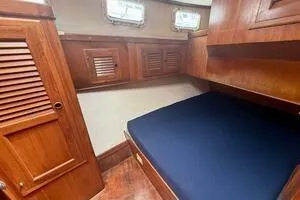 Slide: The Image of 1982 Mainship Trawler cabin interior with wooden finish and blue mattress. - 37