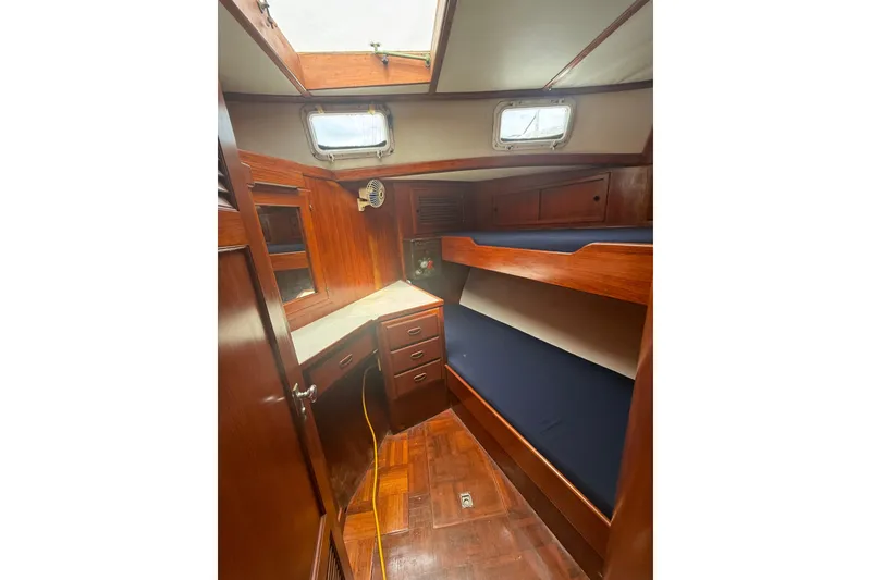 Slide: The Image of 1982 Albin 49 Trawler cabin interior with wooden bunk beds and storage. - 38