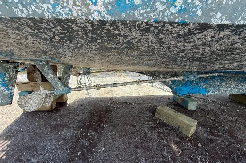 Slide: The Image of Bottom view of 1982 Albin 49 Trawler with barnacle-covered hull on wooden supports. - 45