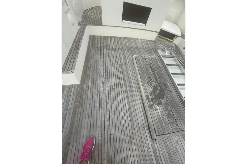 Slide: The Image of 1982 Albin 49 Trawler deck with wooden flooring and pink shoe visible. - 46