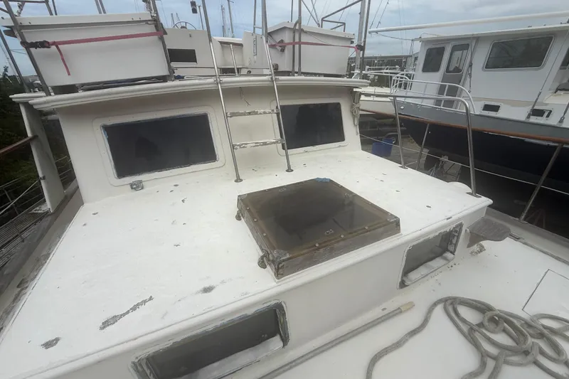 Slide: The Image of 1982 Albin 49 Trawler deck with windows and ladder, docked at marina. - 48