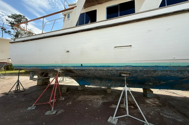 Slide: The Image of 1982 Albin 49 Trawler on stands, showing hull and weathered paint. - 6