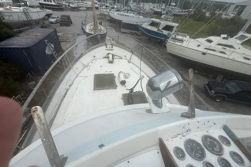 Slide: The Image of 1982 Albin 49 Trawler on dry dock, surrounded by other boats and vehicles. - 8