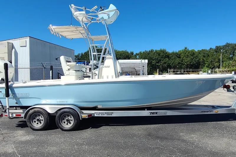 The Image of 2023 Pathfinder 2500 Hybrid boat on trailer, light blue hull, sunny day. - 0