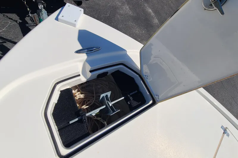 Slide: The Image of Open storage compartment on 2023 Pathfinder 2500 Hybrid boat, showing anchor and rope. - 11