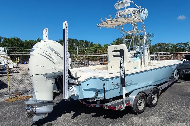 Slide: The Image of 2023 Pathfinder 2500 Hybrid boat with Mercury engine on trailer, parked outdoors. - 2