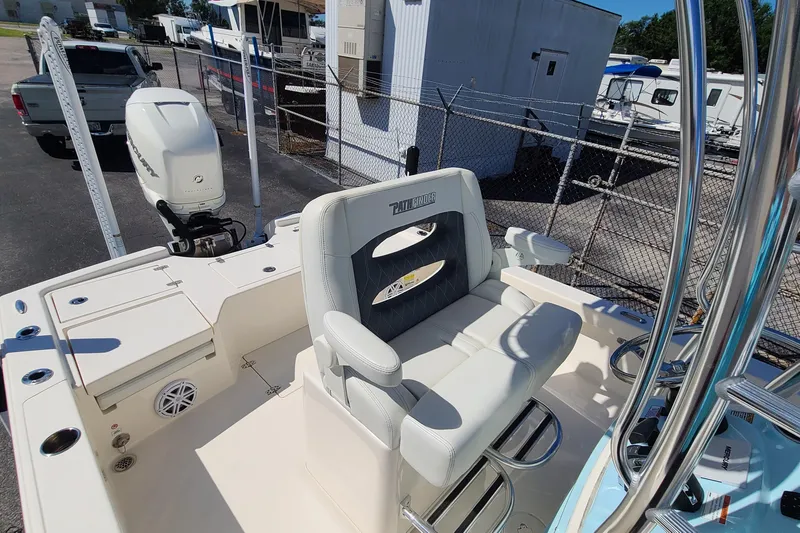 Slide: The Image of 2023 Pathfinder 2500 Hybrid boat interior with seating and motor, parked in a marina. - 27