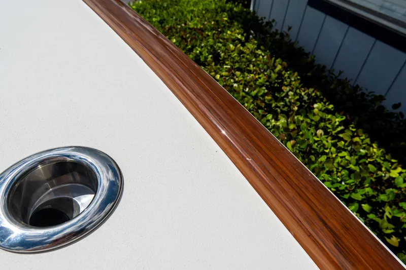 Slide: The Image of Croswait Custom Carolina 21 boat detail, 2022 model, featuring polished metal fitting and wooden trim. - 32