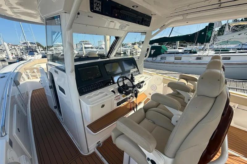 Slide: The Image of 2020 Everglades 435 Center Console boat interior with cushioned seating and teak flooring. - 14