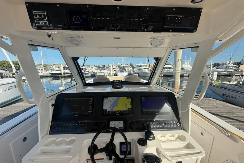 Slide: The Image of 2020 Everglades 435 Center Console boat dashboard with navigation screens on open water. - 16