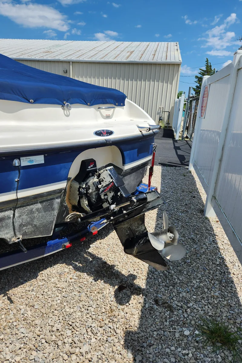 Slide: The Image of 2000 Chaparral 200SSI boat with outboard motor, docked on gravel. - 7