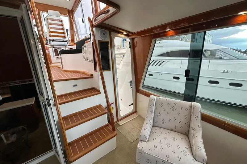 Slide: The Image of Interior of 1998 Viking 54 Motor Yacht with stairs, chair, and large window view. - 12