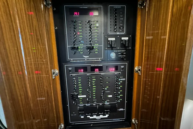 Slide: The Image of Electrical control panel inside a 1998 Viking 54 Motor Yacht, featuring various switches and displays. - 30