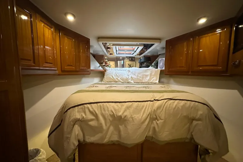 Slide: The Image of Luxurious bedroom interior of 1998 Viking 54 Motor Yacht with wood cabinetry and cozy bedding. - 33