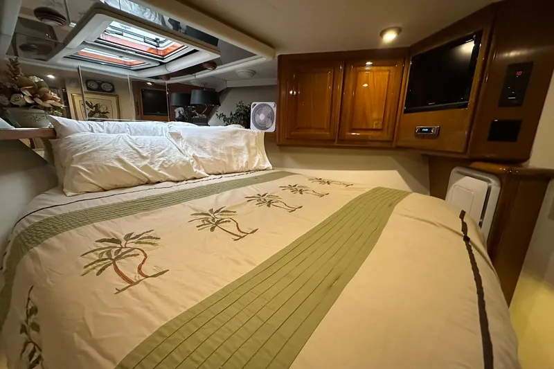 Slide: The Image of Cozy bedroom in 1998 Viking 54 Motor Yacht with palm-themed bedding and wooden cabinetry. - 34
