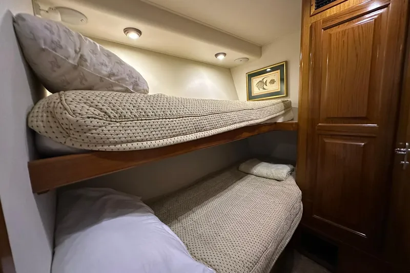 Slide: The Image of Bunk beds in 1998 Viking 54 Motor Yacht cabin with cozy lighting and wooden accents. - 37
