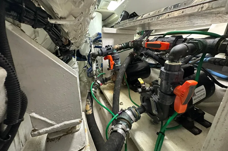 Slide: The Image of Engine room of a 1998 Viking 54 Motor Yacht with visible pipes and valves. - 49