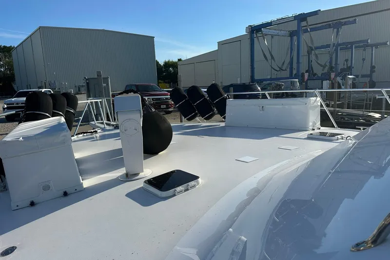 Slide: The Image of 1998 Viking 54 Motor Yacht deck view at a marina with equipment and vehicles. - 9