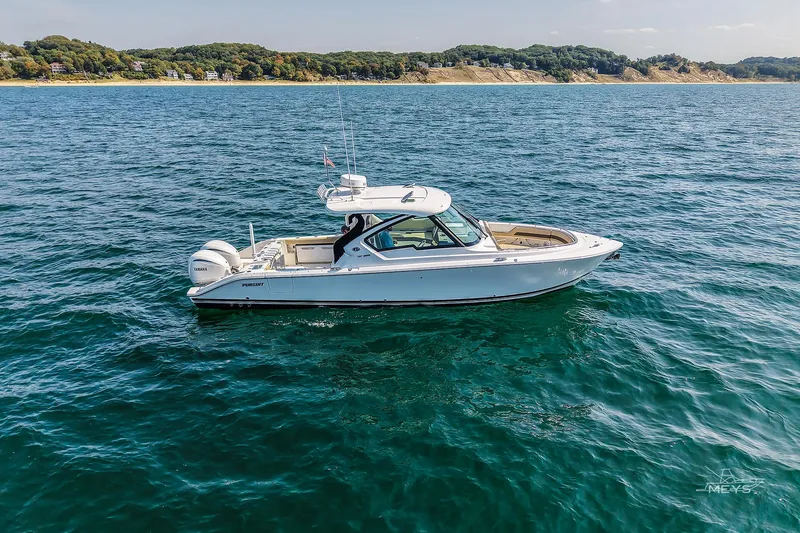 Slide: The Image of 2021 Pursuit DC 326 Dual Console boat cruising on open water. - 2