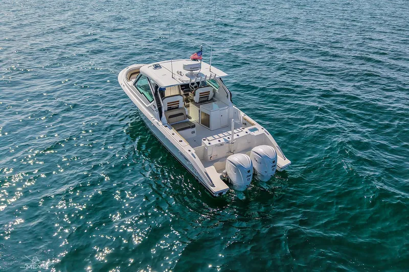 Slide: The Image of 2021 Pursuit DC 326 Dual Console boat on open water, featuring twin engines. - 5