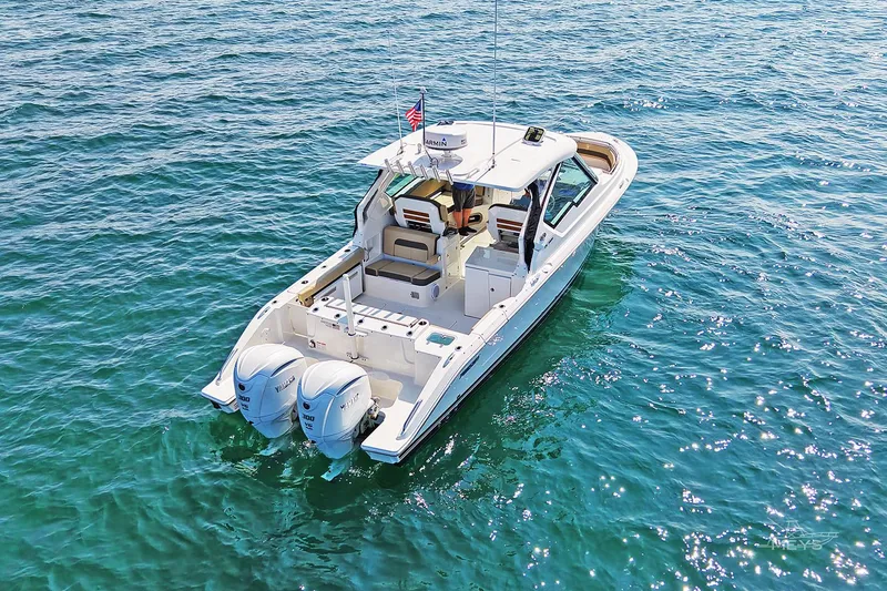 Slide: The Image of 2021 Pursuit DC 326 Dual Console boat on clear blue water. - 6