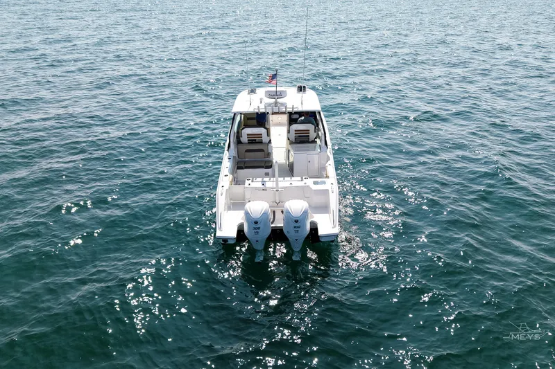Slide: The Image of 2021 Pursuit DC 326 Dual Console boat on open water, rear view. - 7