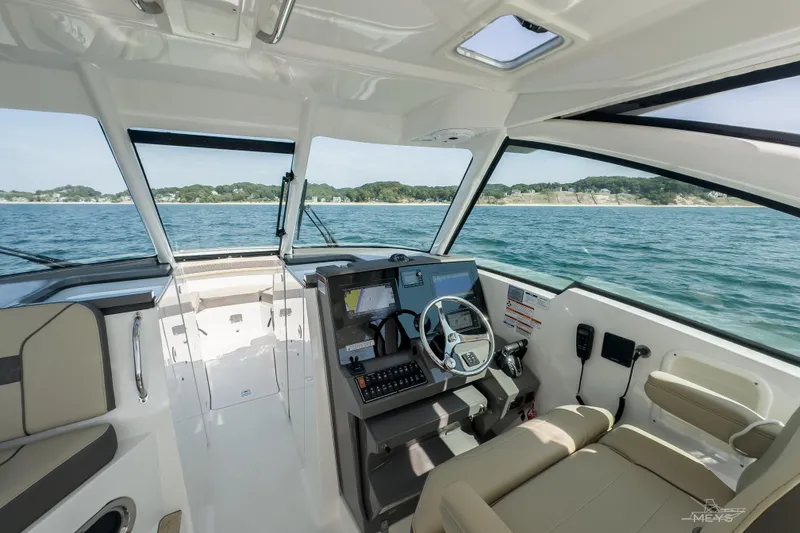 Slide: The Image of 2021 Pursuit DC 326 Dual Console boat interior with ocean view and modern dashboard. - 8