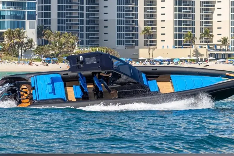 The Image of 2025 Technohull 38 Gran speedboat cruising near a beachfront with modern buildings. - 1