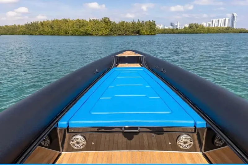 Slide: The Image of 2025 Technohull 38 Gran boat on serene water with city skyline in background. - 10