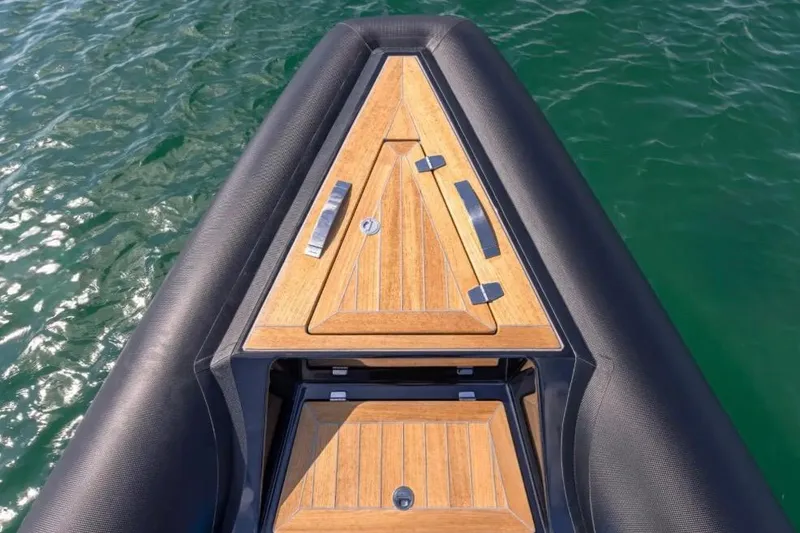 Slide: The Image of Bow of 2025 Technohull 38 Gran with sleek wooden deck design on water. - 11