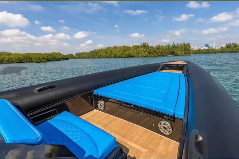 Slide: The Image of 2025 Technohull 38 Gran boat with blue seating on a serene waterway. - 14